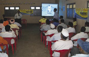 A section of the audience watching a video film in the local language on Trubore products.