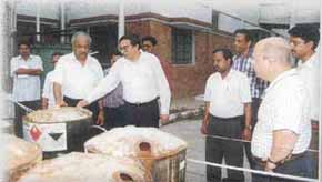 C G Sethuram showing the emptied bulged drums kept after neutralisation to M Devaraj during his visit to the Alathur factory. David Stermole of PPG is on the right. 