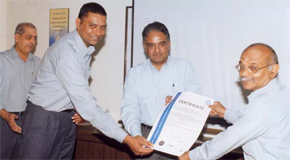 K Muthuraman, AVP - Operations and G Sankarasubramanian, Manager - Production, handing over the ISO 14001 certificate to P S
Jayaraman, Managing Director, during his visit to Mettur on 13th July 2005. V Ranganathan, Chief Executive - Operations looking on.